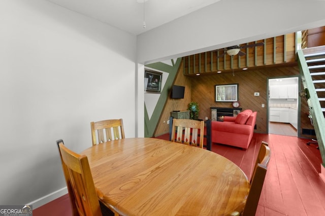 115 Rabbit Run, Dawsonville, GA 30534 - dining space featuring wood walls, a lit fireplace, ceiling fan, and hardwood / wood-style floors