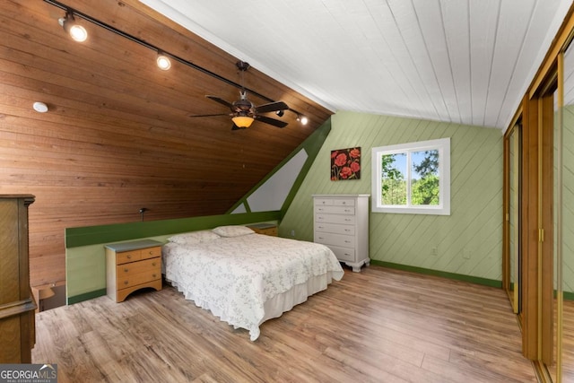 115 Rabbit Run, Dawsonville, GA 30534 - bedroom featuring lofted ceiling, wood finished floors, baseboards, wooden walls, and rail lighting