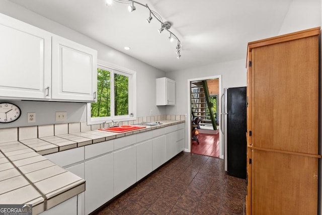115 Rabbit Run, Dawsonville, GA 30534 - kitchen featuring a sink, tile counters, freestanding refrigerator, and white cabinetry