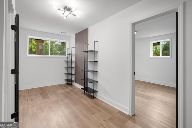 empty room with light wood-style floors, baseboards, and visible vents