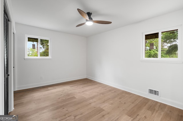 unfurnished bedroom with baseboards, multiple windows, and light wood-type flooring