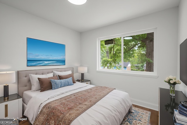bedroom with baseboards and wood finished floors