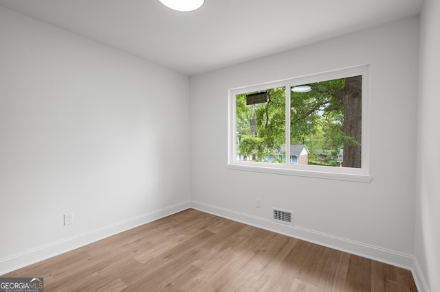 unfurnished room featuring baseboards, visible vents, and light wood-type flooring
