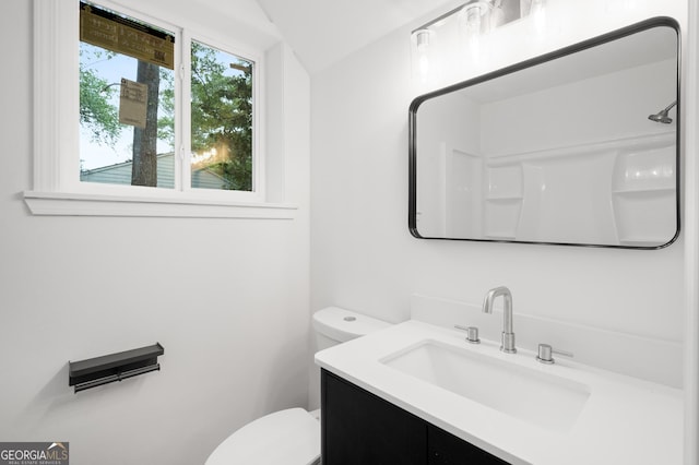 bathroom with vanity, vaulted ceiling, and toilet
