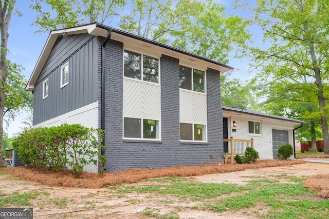 view of front of house with board and batten siding, brick siding, and a garage