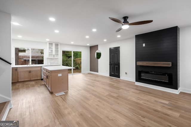 kitchen with light countertops, a center island, ceiling fan, and light wood finished floors