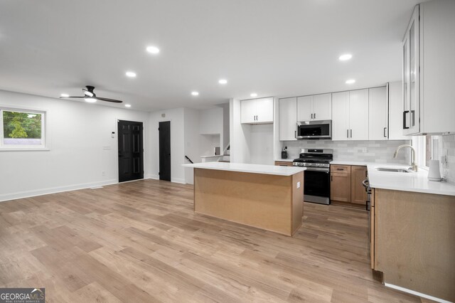 kitchen featuring decorative backsplash, a center island, recessed lighting, a sink, and appliances with stainless steel finishes