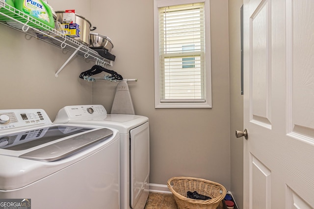 clothes washing area featuring washing machine and dryer and baseboards