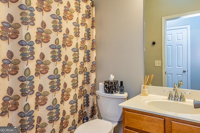 bathroom featuring toilet, vanity, and a shower with shower curtain
