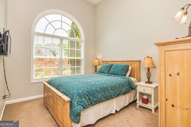 carpeted bedroom featuring multiple windows and baseboards