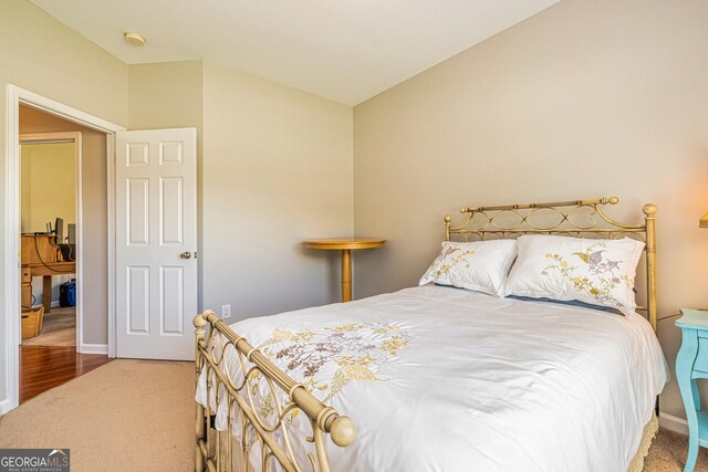 carpeted bedroom featuring lofted ceiling and baseboards