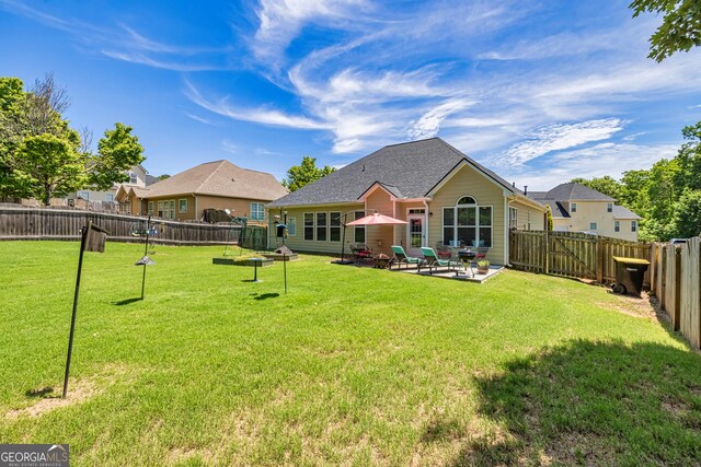 rear view of house with a patio area and a shingled roof