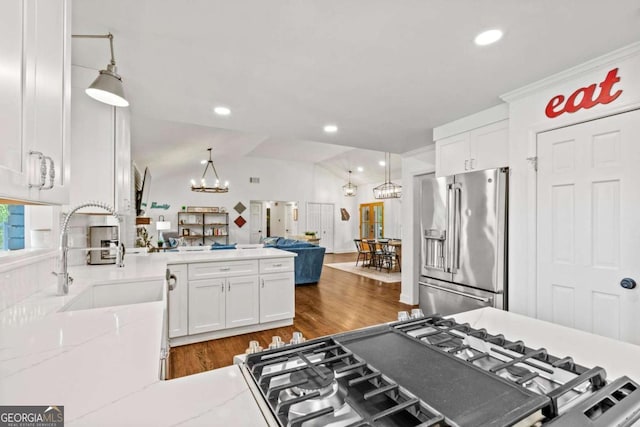 kitchen featuring an inviting chandelier, high quality fridge, white cabinetry, and open floor plan