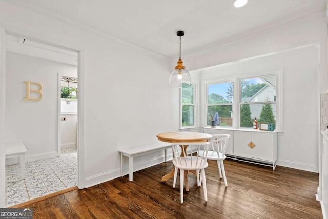 dining room featuring crown molding, baseboards, a baseboard radiator, and wood finished floors
