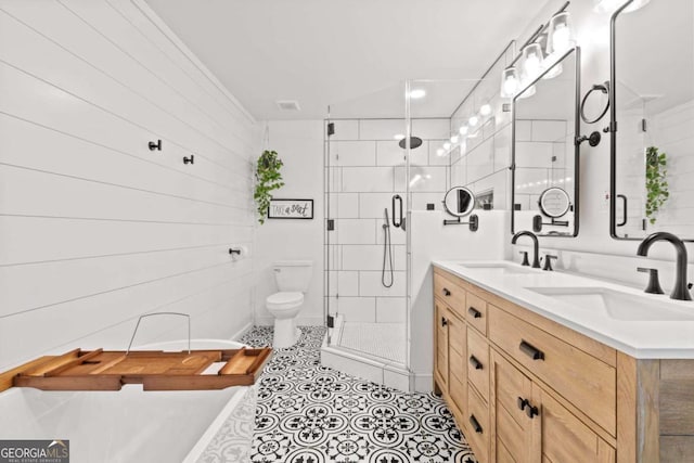 bathroom featuring double vanity, a freestanding tub, a shower stall, and a sink