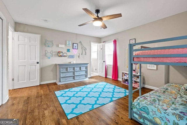 bedroom with baseboards, ceiling fan, and wood finished floors