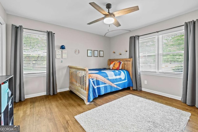bedroom featuring baseboards, ceiling fan, and wood finished floors