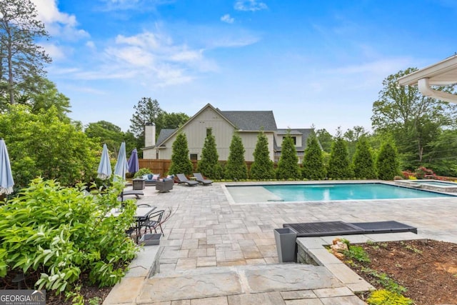 view of swimming pool featuring a pool with connected hot tub and a patio area
