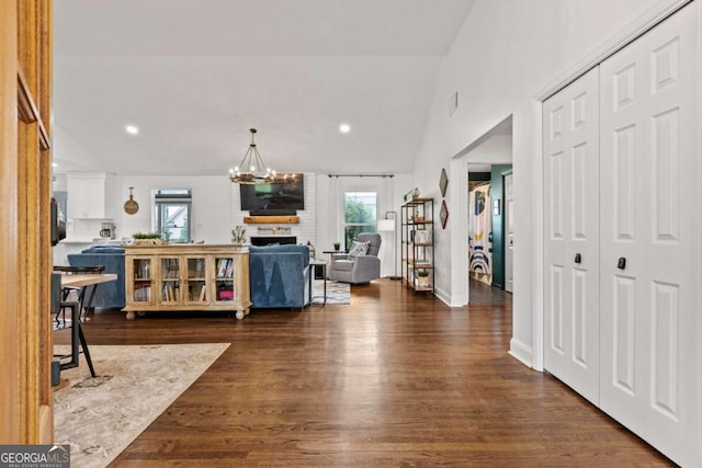 interior space with a fireplace, recessed lighting, a notable chandelier, and dark wood-type flooring