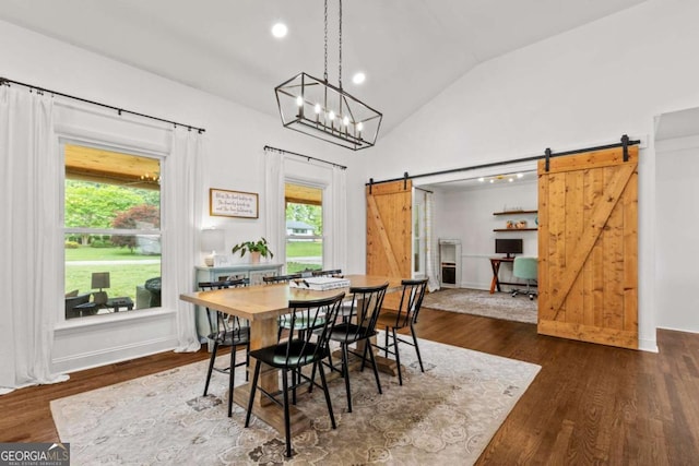 dining room featuring recessed lighting, dark wood-style floors, a barn door, and lofted ceiling