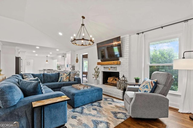 living room with a fireplace, a chandelier, recessed lighting, wood finished floors, and lofted ceiling