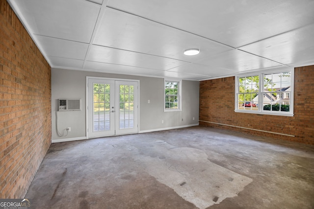 115 Linda Way, Fayetteville, GA 30215 - unfurnished living room featuring an AC wall unit, concrete floors, baseboards, and brick wall