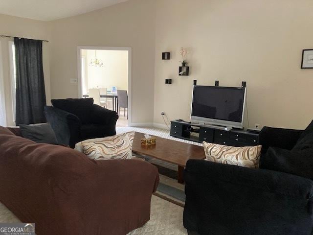 140 Cedar Creek Dr, Dublin, GA 31021 - living room featuring a notable chandelier, light colored carpet, baseboards, and vaulted ceiling