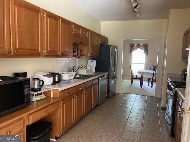 140 Cedar Creek Dr, Dublin, GA 31021 - kitchen featuring light countertops, brown cabinets, appliances with stainless steel finishes, and a sink