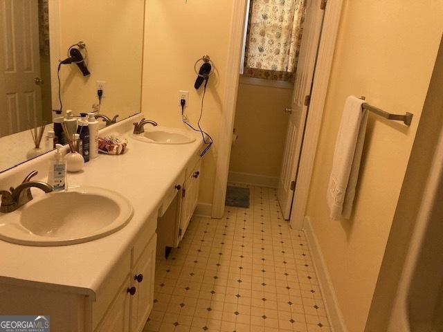 140 Cedar Creek Dr, Dublin, GA 31021 - full bathroom with a sink, tile patterned floors, baseboards, and double vanity