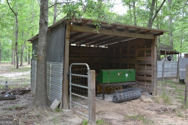 view of outdoor structure featuring an exterior structure, a wooded view, and an outdoor structure