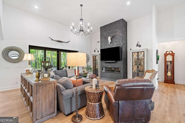 281 Abbott Dr, Canton, GA 30114 - living area with a high ceiling, baseboards, a chandelier, a fireplace, and light wood-style flooring