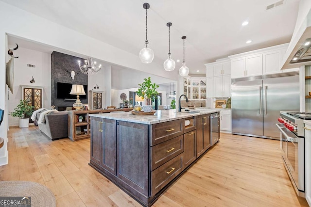 281 Abbott Dr, Canton, GA 30114 - kitchen featuring high end appliances, white cabinets, dark brown cabinetry, a sink, and light wood-type flooring