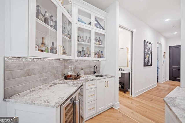 281 Abbott Dr, Canton, GA 30114 - indoor wet bar with light wood-type flooring, beverage cooler, tasteful backsplash, baseboards, and recessed lighting