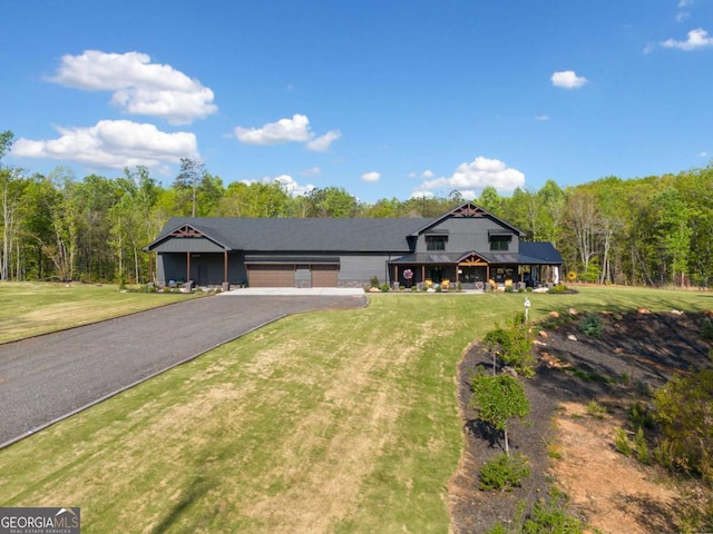 281 Abbott Dr, Canton, GA 30114 - view of front of house with asphalt driveway, a garage, a front yard, and a wooded view