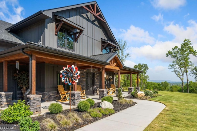 281 Abbott Dr, Canton, GA 30114 - view of front of house featuring board and batten siding, a front yard, stone siding, and a porch