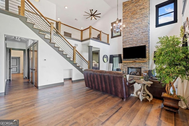 281 Abbott Dr, Canton, GA 30114 - living area featuring a high ceiling, wood finished floors, a fireplace, stairs, and a chandelier