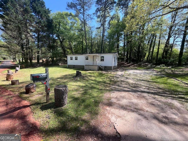 manufactured / mobile home with driveway and a front yard