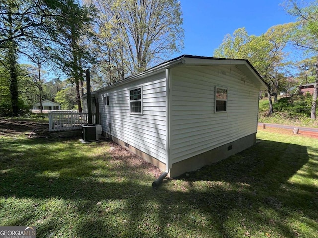 view of side of property featuring a yard, crawl space, central AC, and a deck