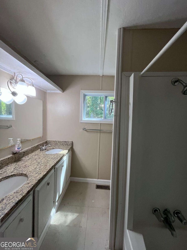 full bath with double vanity, baseboards, visible vents, and a sink