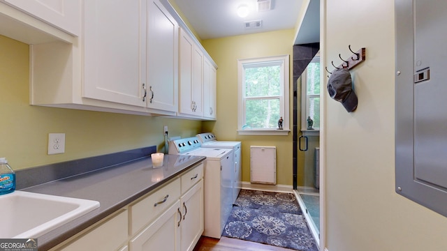 laundry area with cabinet space, a sink, visible vents, and washer and clothes dryer