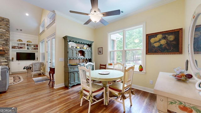 dining area with crown molding, visible vents, baseboards, a ceiling fan, and light wood-style flooring