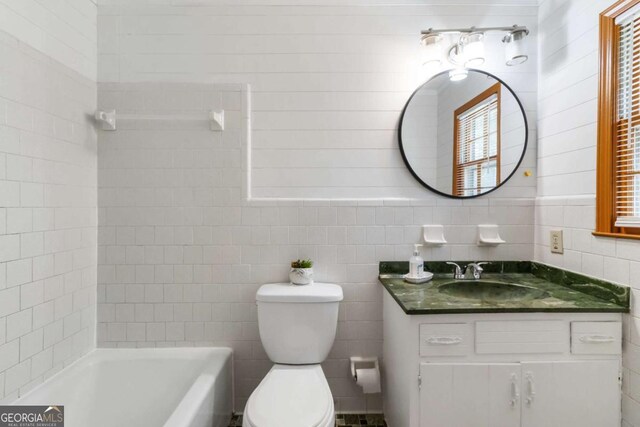 5152 Clearwater Dr, Stone Mountain, GA 30087 - full bathroom featuring vanity, toilet, tile walls, and a bathtub