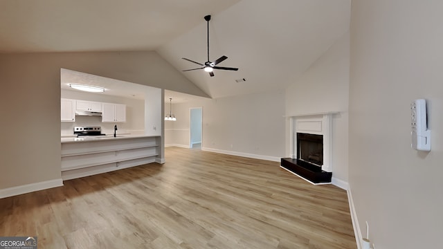 931 Justin Dr, Winder, GA 30680 - unfurnished living room with a ceiling fan, visible vents, light wood-type flooring, high vaulted ceiling, and a fireplace with raised hearth