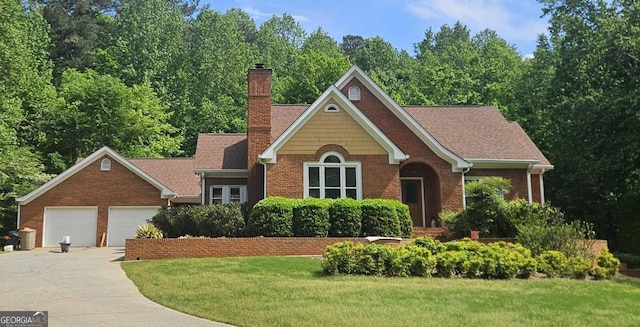 view of front facade with a chimney, brick siding, a front lawn, driveway, and a garage