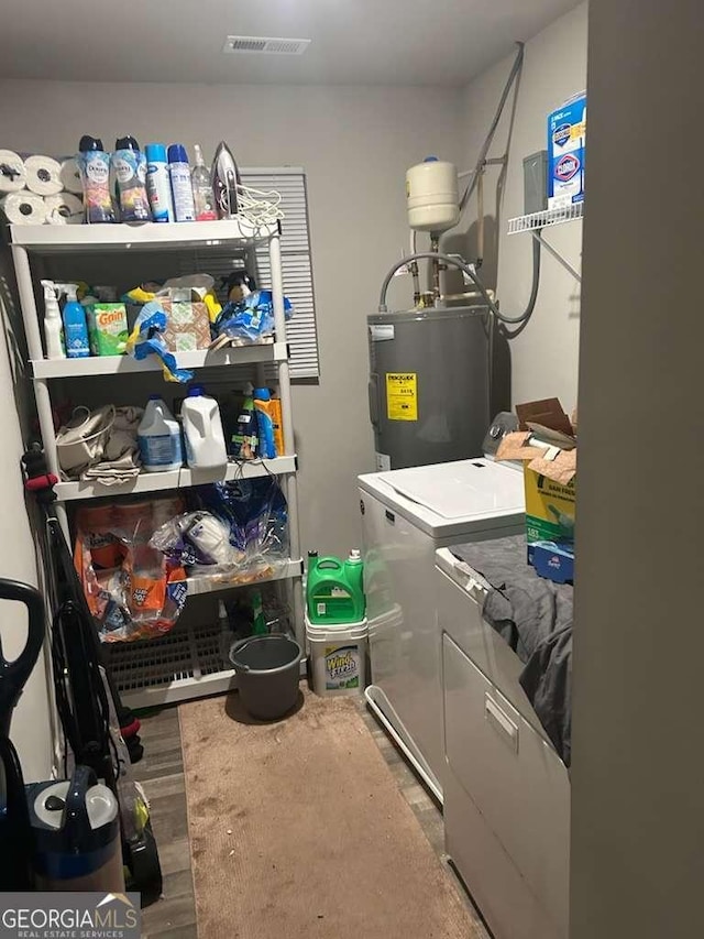 713 Dove Tree Ln, Social Circle, GA 30025 - washroom featuring washer and dryer, laundry area, visible vents, and electric water heater