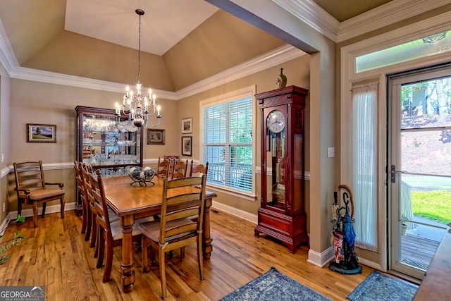 dining space with crown molding, baseboards, an inviting chandelier, and light wood finished floors