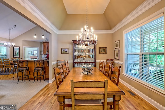 dining area with light wood-style floors, a wealth of natural light, and a chandelier