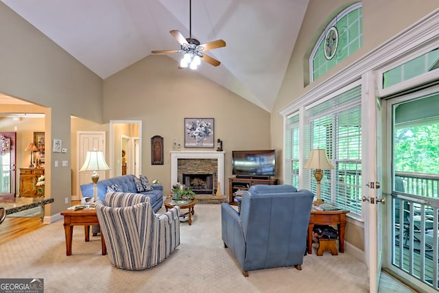 living room with a healthy amount of sunlight, ceiling fan, a fireplace, and light colored carpet