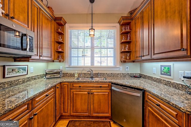 kitchen featuring decorative light fixtures, appliances with stainless steel finishes, open shelves, a sink, and dark stone countertops