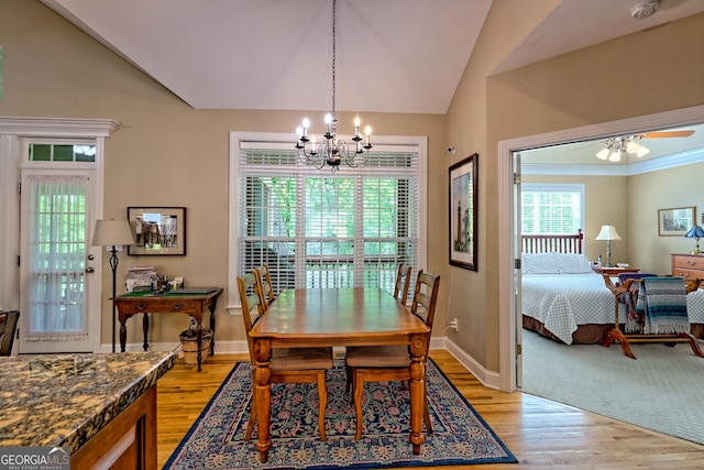 dining area featuring light wood-style floors, baseboards, vaulted ceiling, and ceiling fan with notable chandelier